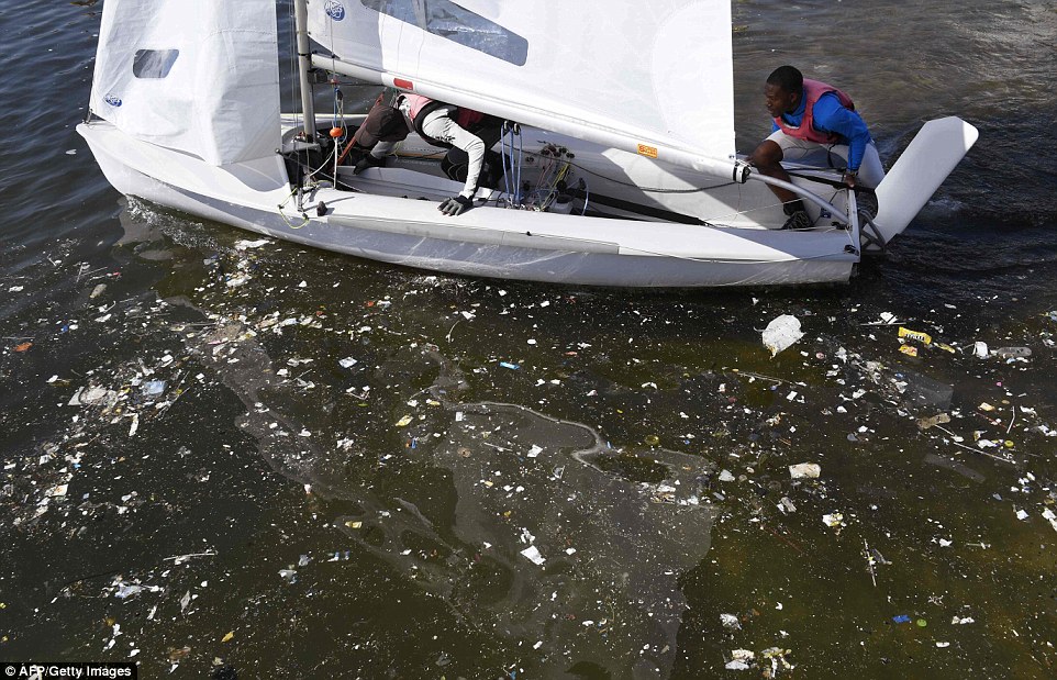 Waste litters the water as two sailors prepare for a training session at Rio de Janeiro's Guanabara Bay. Image: AFP/Getty Images.